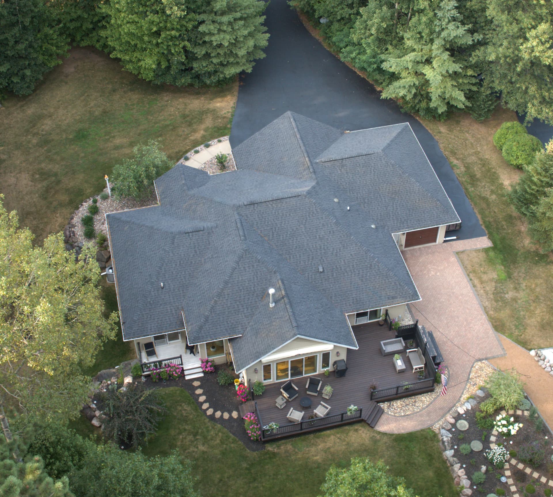 Aerial view of a Northwoods home with new charcoal architectural shingles and multiple intersecting gables