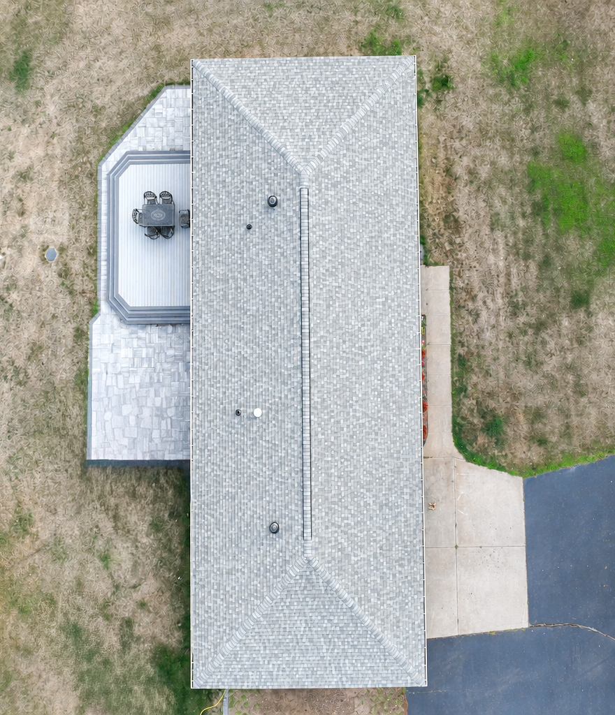 Aerial view of a ranch home roof with continuous ridge vent and light grey shingles