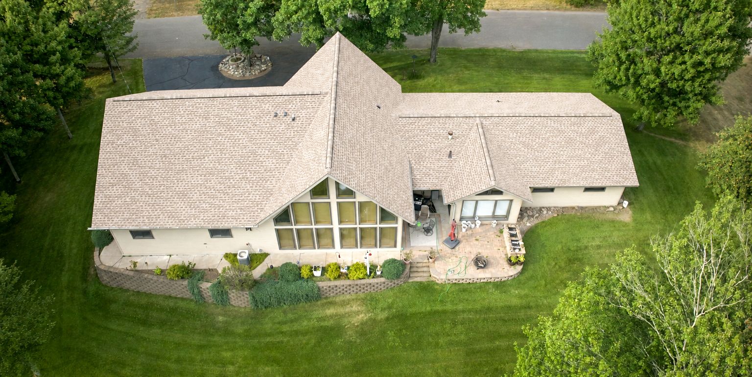 Aerial view of a lake home showing intersecting gables, valleys and ridge lines