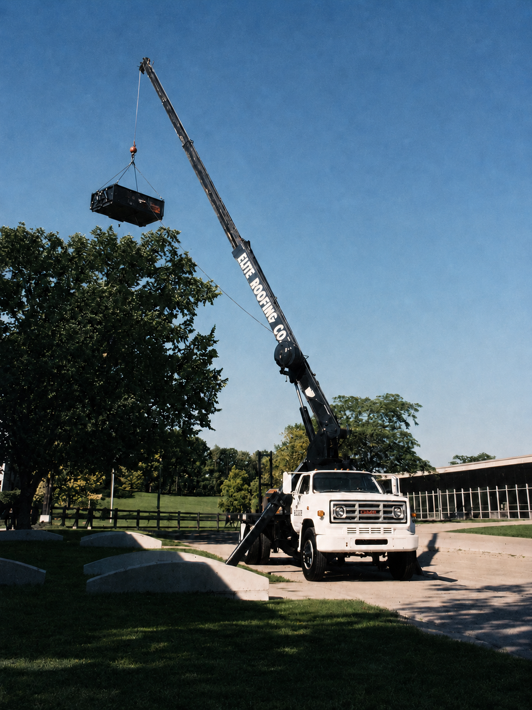 Elite Roofing and Sheet Metal crane truck hoisting materials on a commercial roofing site in Milwaukee, WI
