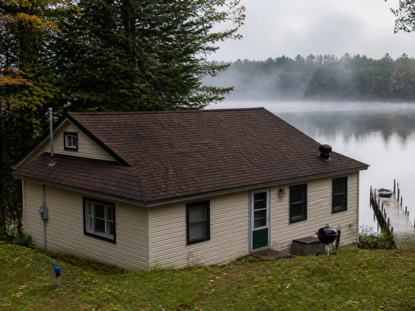 Northwoods cottage among tall pines with a new Roof Masters roof