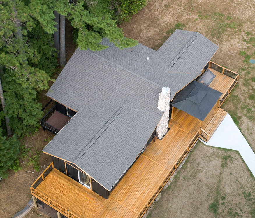 Aerial view of a cabin roof with covered entry and new architectural shingles